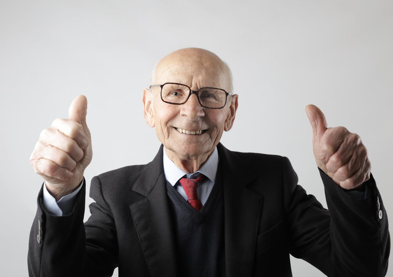 Elderly man gives two thumbs up.