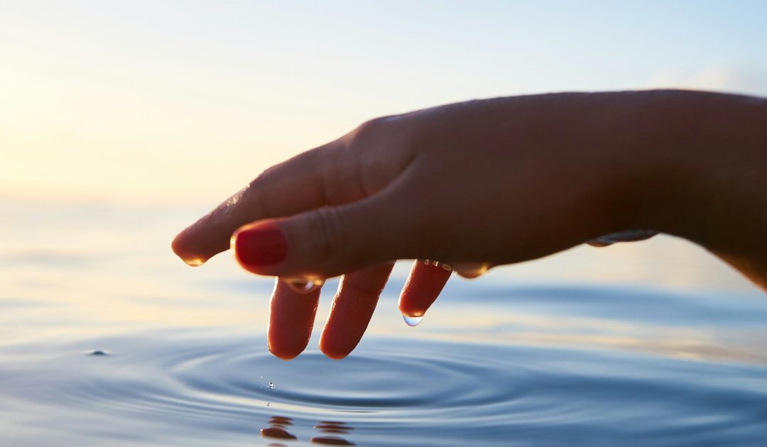 A hand touching water.